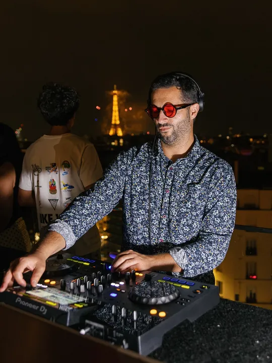 ANYMEN aux platines sur un rooftop parisien, la tour Eiffel en arrière-plan